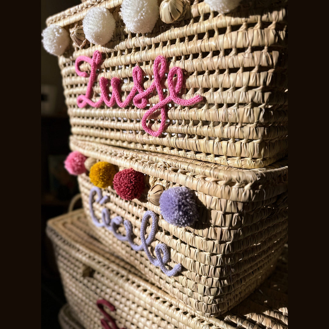 Detail van punnik naam op een handgemaakte mand van 60 cm uit palmblad.
