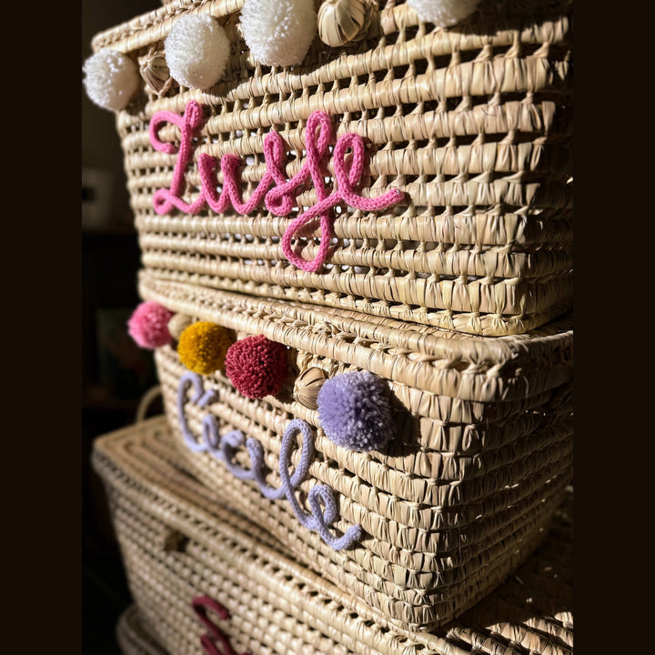 Detail van punnik naam op een handgemaakte mand van 60 cm uit palmblad.
