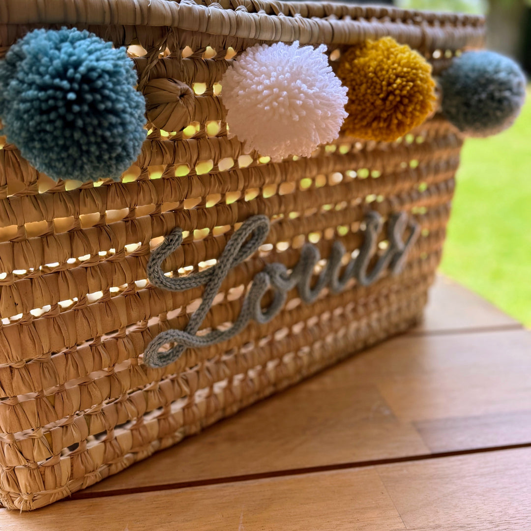 Detail van punnik naam op een handgemaakte mand van 60 cm uit palmblad.
