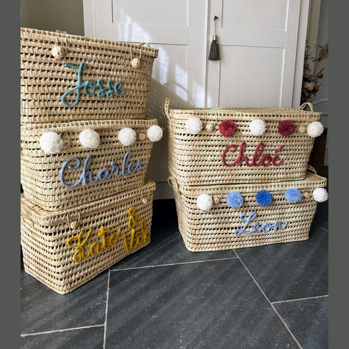 Detail van punnik naam op een handgemaakte mand van 60 cm uit palmblad.
