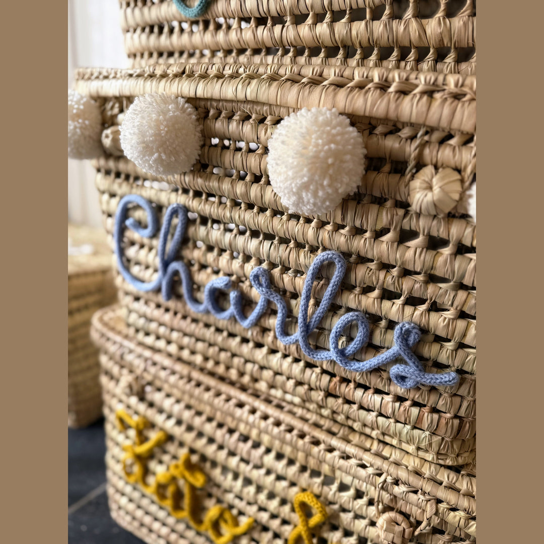 Detail van punnik naam op een handgemaakte mand van 60 cm uit palmblad.
