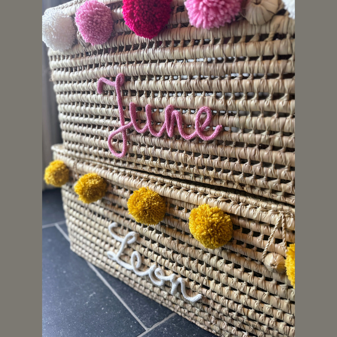 Detail van punnik naam op een handgemaakte mand van 60 cm uit palmblad.
