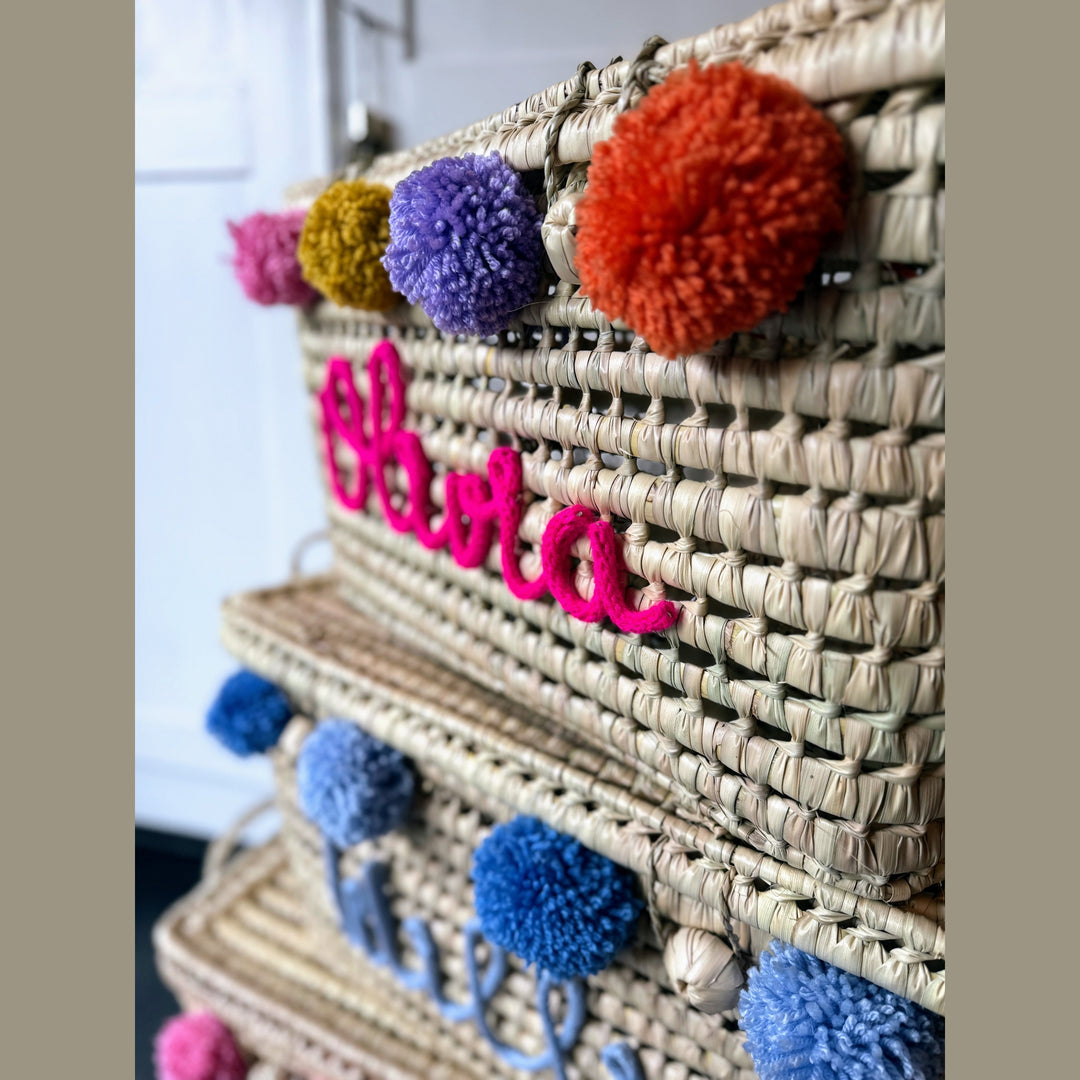 Detail van punnik naam op een handgemaakte mand van 60 cm uit palmblad.
