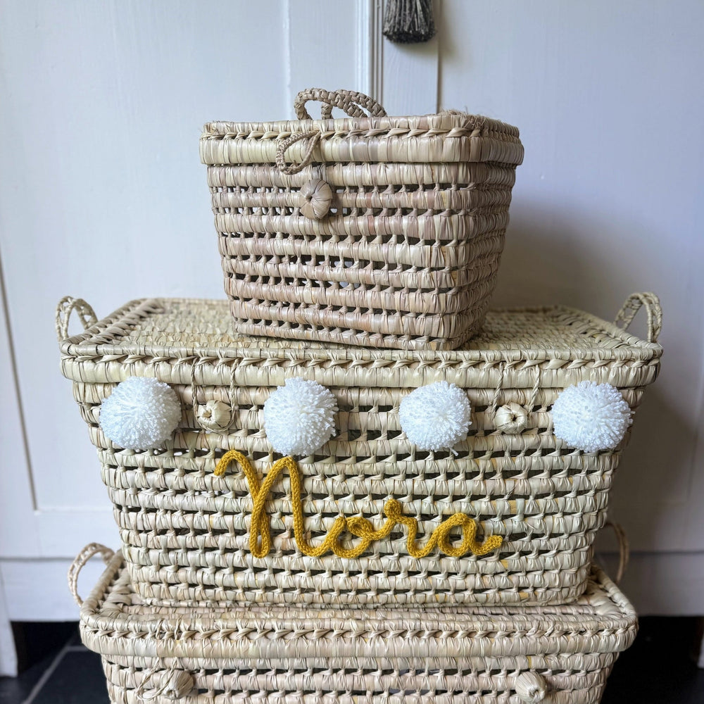 Speelgoedmand met kleurrijke pompons, perfect als eyecatcher in de kinderkamer.