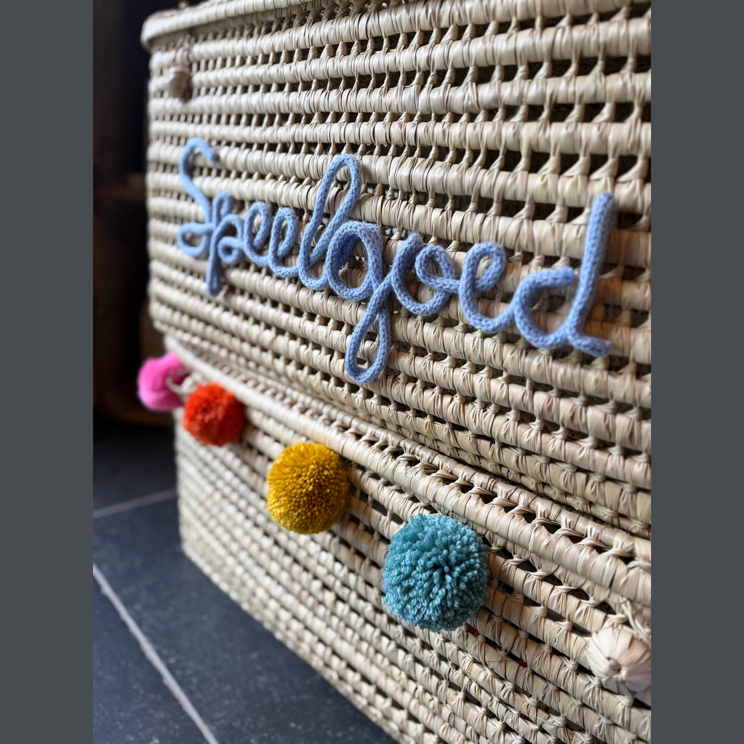 Detail van punnik naam op een handgemaakte mand van 60 cm uit palmblad.
