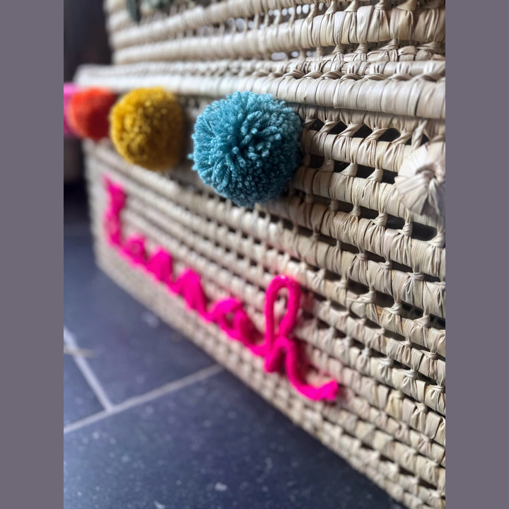 Detail van punnik naam op een handgemaakte mand van 60 cm uit palmblad.
