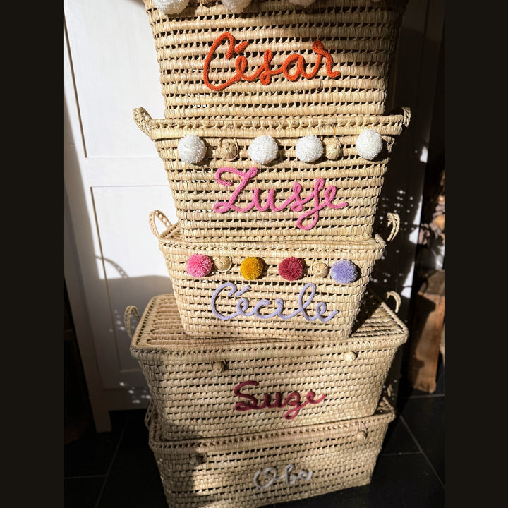 Detail van punnik naam op een handgemaakte mand van 60 cm uit palmblad.
