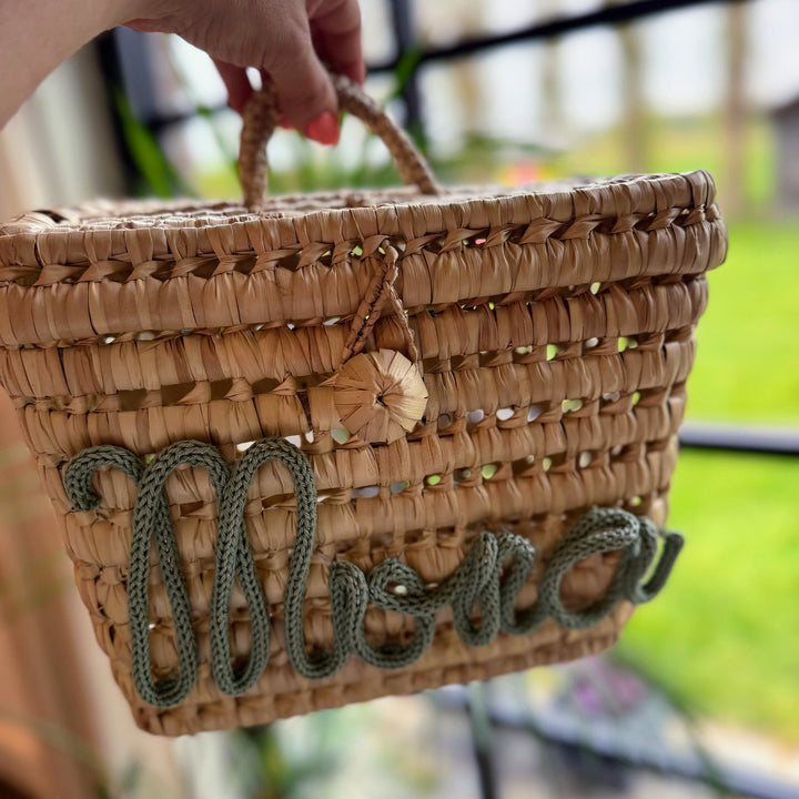 Speelgoedmand met kleurrijke pompons, perfect als eyecatcher in de kinderkamer.
