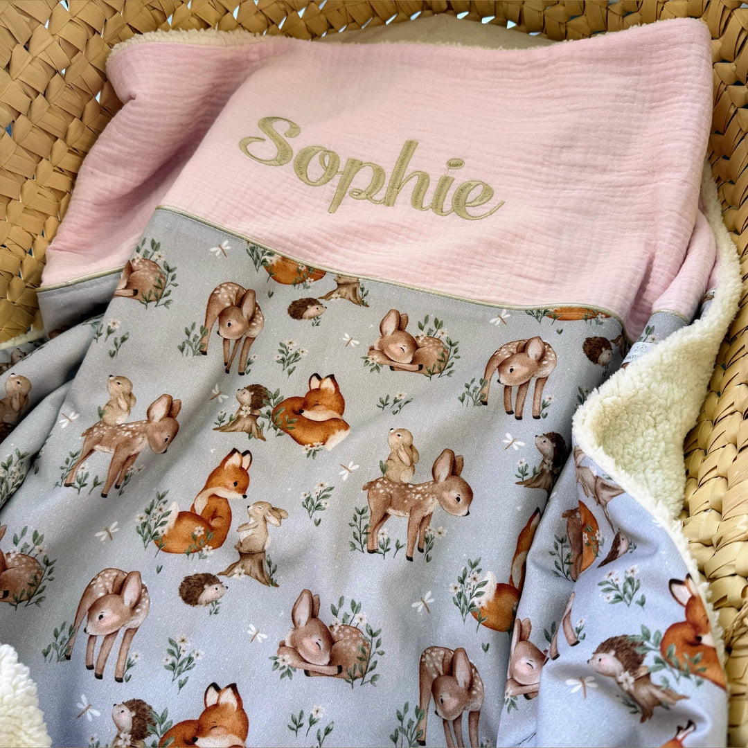 Handgemaakt babydeken met bosdierenprint en geborduurde naam.