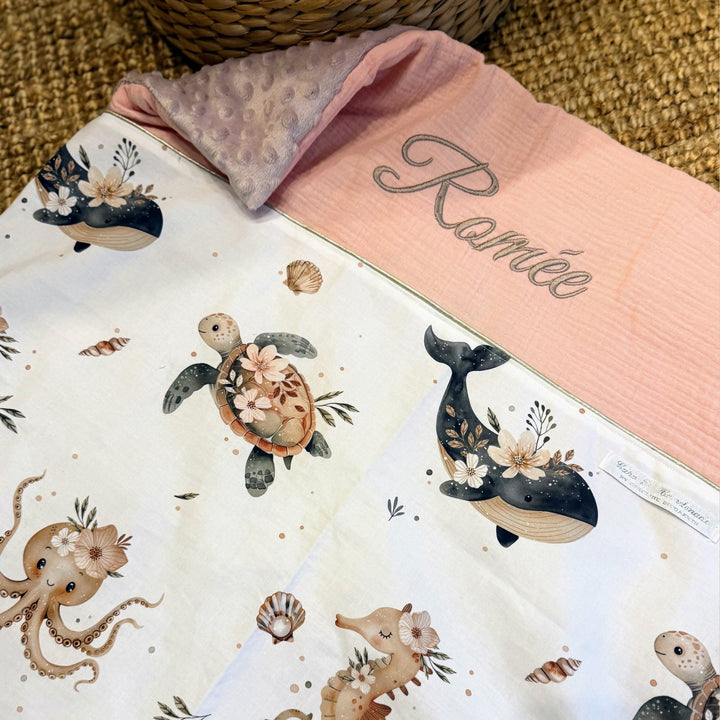 Babydeken met zeedierenprint, donkerblauwe stof en lichte zachte achterkant.