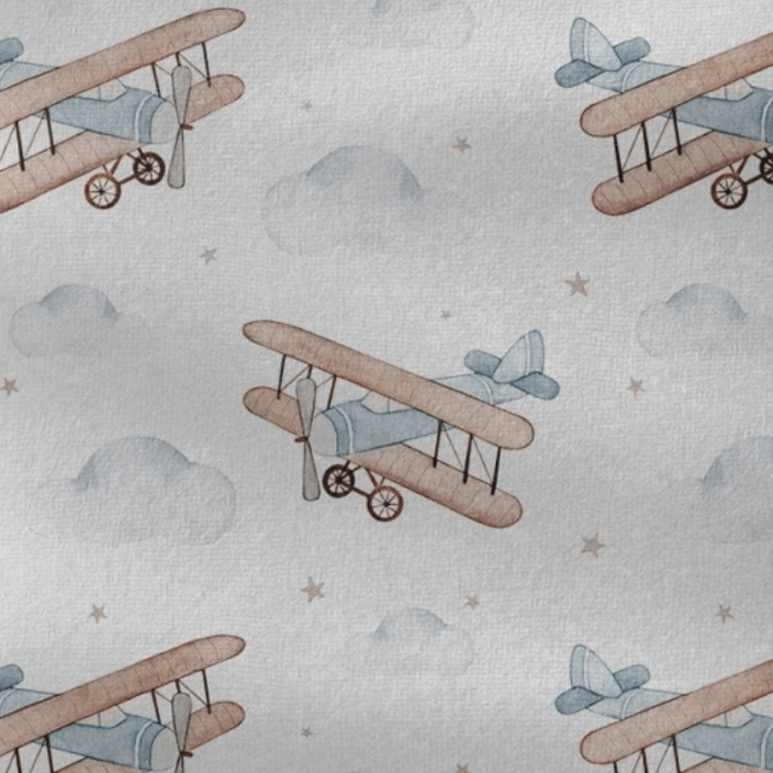 Stofprint met kleine vliegtuigen, wolken en sterren in blauw, beige en grijs.