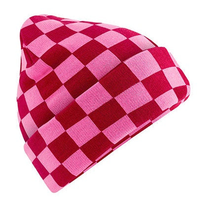 Gebreide schaakbordmuts in roze en bordeaux met contrasterende blokken.
