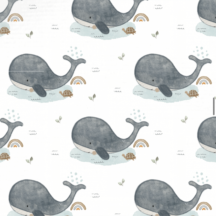 Stofprint met walvis, schildpad en regenboog op een lichte achtergrond.
